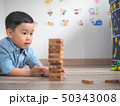 Small kid playing with wooden blocks on the floor 50343008