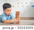 Small kid playing with wooden blocks on the floor 50343009