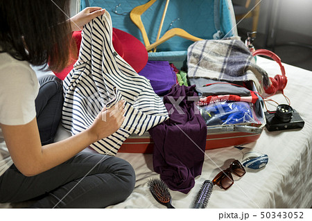 Woman hand packing a luggage for a new journey and Woman hand packing a luggage for a new journey and 50343052