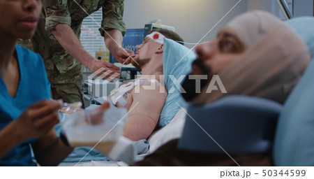 Nurse feeding injured soldiers in hospital bed Nurse feeding injured soldiers in hospital bed 50344599