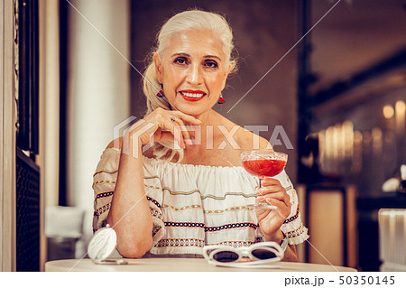 Smiling grey-haired woman with red lips wearing off-shoulder blouse Smiling grey-haired woman with red lips wearing off-shoulder blouse 50350145