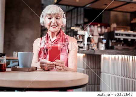Peaceful short-haired old woman enjoying favorite music 50351645