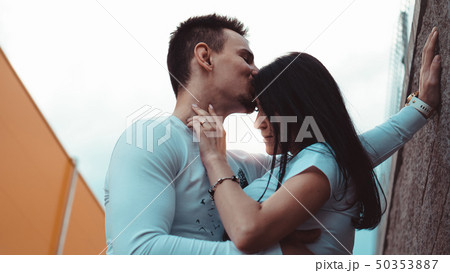 Young loving couples standing next to the brick wall, happy and satisfied 50353887