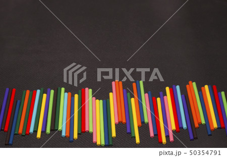 multicolored sticks lay on a black background. multicolored sticks lay on a black background. 50354791