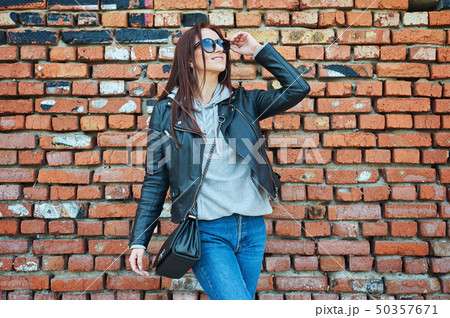Young redhead woman posing near the brick wall 50357671