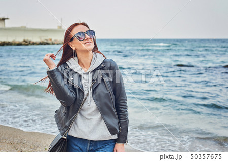 Beautiful young redhead woman staying at the beach 50357675