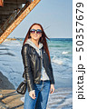 Beautiful young redhead woman staying at the beach 50357679