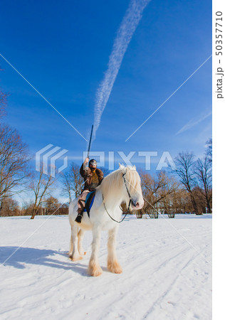 Man in suit of ancient warrior raising his sword Man in suit of ancient warrior raising his sword 50357710