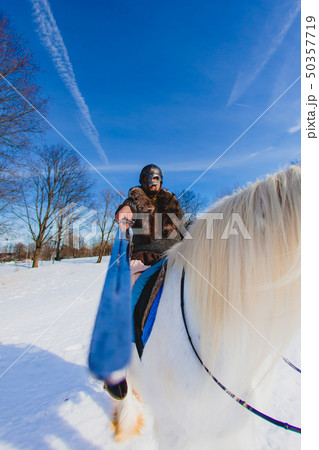 Man in suit of ancient warrior riding big white horse 50357719