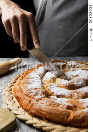 man cutting ensaimada typical of Mallorca, Spain 50358053