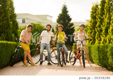Four friends resting with bicycles. 50358280