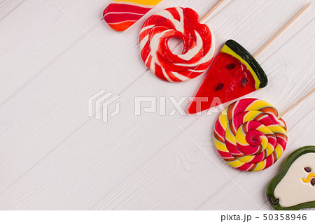 Colorful candies on white wooden background. 50358946