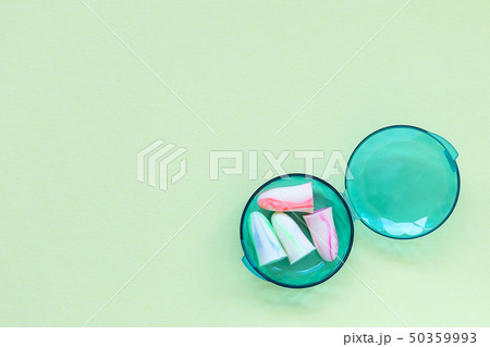 Earplugs in a box on the green background. 50359993