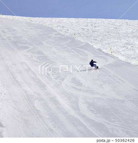 Snowy ski slope and snowboarder at sun day 50362426