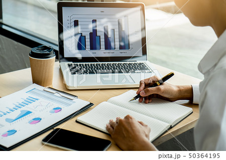 Business adviser analyzing financial figures Business adviser analyzing financial figures 50364195