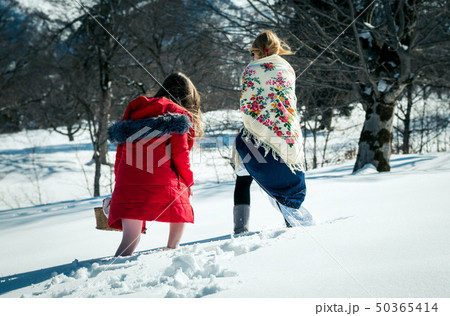 Girl with mum walking in the snow Girl with mum walking in the snow 50365414