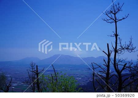 煙を吐く阿蘇山と阿蘇町の風景 50369920