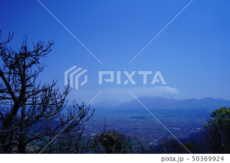 煙を吐く阿蘇山と阿蘇町の風景 50369924