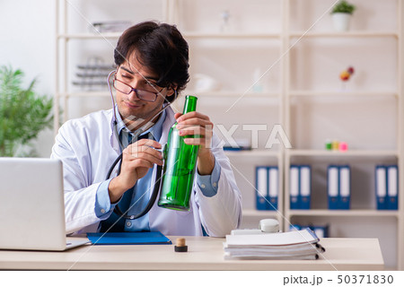 Young male doctor drinking in the office Young male doctor drinking in the office 50371830