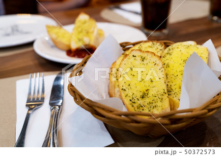 Garlic bread in basket with knife and fork Garlic bread in basket with knife and fork 50372573