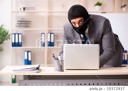 Male gangster stealing information from the office  50372837