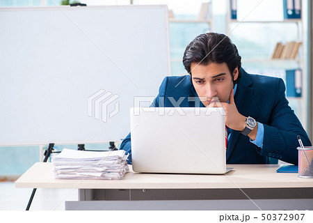 Young handsome businessman in front of whiteboard Young handsome businessman in front of whiteboard 50372907