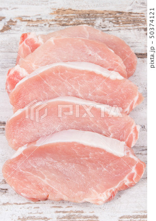 Slices of fresh loin for cooking on rustic board Slices of fresh loin for cooking on rustic board 50374121