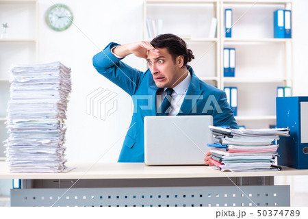 Young male employee unhappy with excessive work Young male employee unhappy with excessive work 50374789