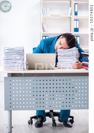 Young male employee unhappy with excessive work  50374803