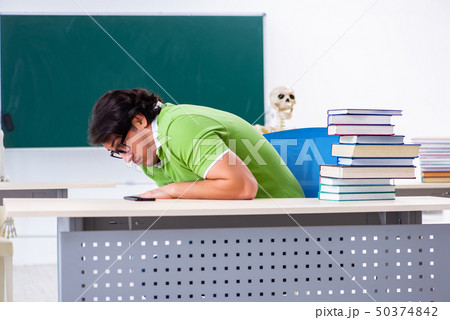 Young male student in front of green board  50374842