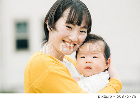 赤ちゃんを抱く若い母親 日本人親子の写真素材