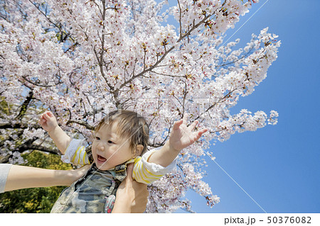 桜の咲く公園で遊ぶ母と娘 50376082