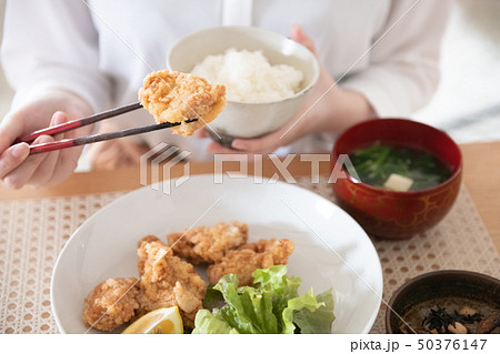 鶏の唐揚げを食べる若い女性の手元 50376147