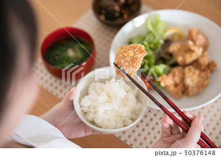 鶏の唐揚げを食べる若い女性の手元 50376148