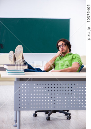 Young male student in front of green board Young male student in front of green board 50376406