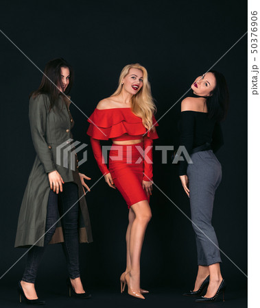 young women friends standing over black background 50376906