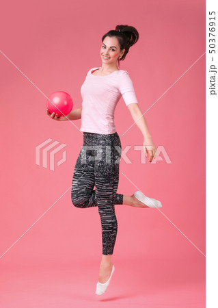 smiling woman jumping with the ball 50376915