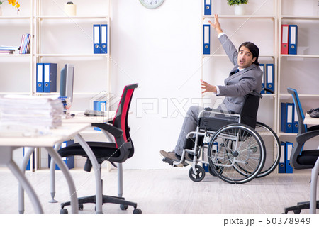 Young handsome employee in wheelchair working in the office   50378949
