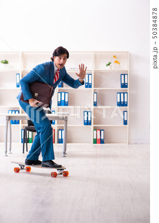 Young handsome businessman with longboard in the office Young handsome businessman with longboard in the office 50384878