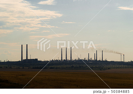The silhouette of a huge gas and oil processing plant with burning torches, pipes and distillation The silhouette of a huge gas and oil processing plant with burning torches, pipes and distillation 50384885