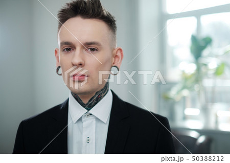 Portrait of alternative model with earplugs and tattoo Portrait of alternative model with earplugs and tattoo 50388212