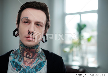 Portrait of alternative model with earplugs and tattoo Portrait of alternative model with earplugs and tattoo 50388244