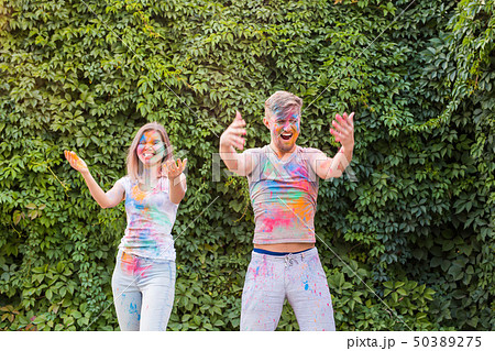 Friendship, festival of holi, people concept - young couple playing with colors at the festival of Friendship, festival of holi, people concept - young couple playing with colors at the festival of 50389275