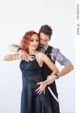 Social dance, bachata, kizomba, zouk, tango concept - Man hugs woman while dancing over white Social dance, bachata, kizomba, zouk, tango concept - Man hugs woman while dancing over white 50389345
