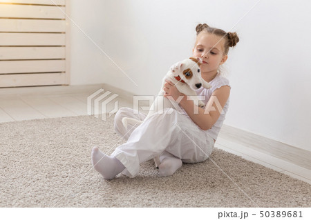People, pets and animal concept - Little girl sitting on the floor over white background and holding People, pets and animal concept - Little girl sitting on the floor over white background and holding 50389681