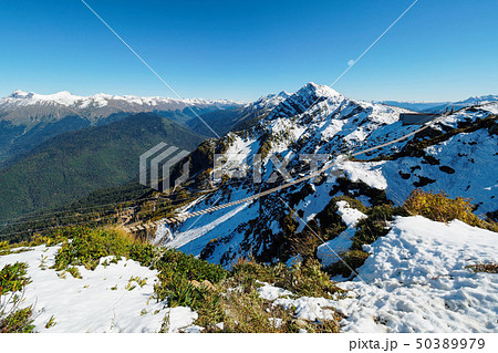 Suspension footbridge in the high snowy mountains. Suspension footbridge in the high snowy mountains. 50389979