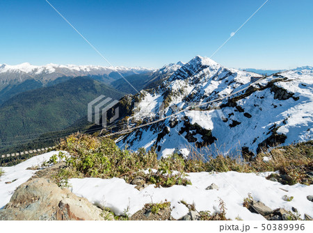 Suspension footbridge in the high snowy mountains. 50389996
