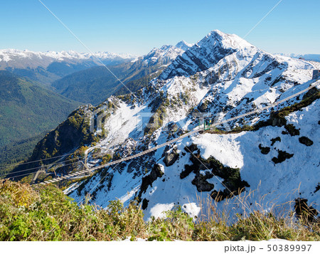 Suspension footbridge in the high snowy mountains. Suspension footbridge in the high snowy mountains. 50389997
