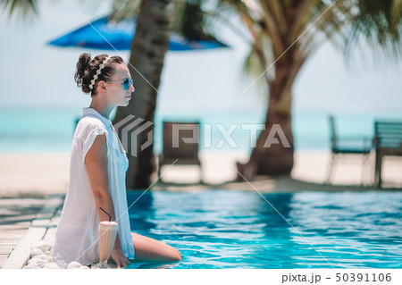 Young beautiful woman enjoying the luxurious quiet swimming pool 50391106
