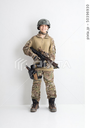 白背景迷彩服を着た女の子サバイバルゲールサバゲー体験の写真素材